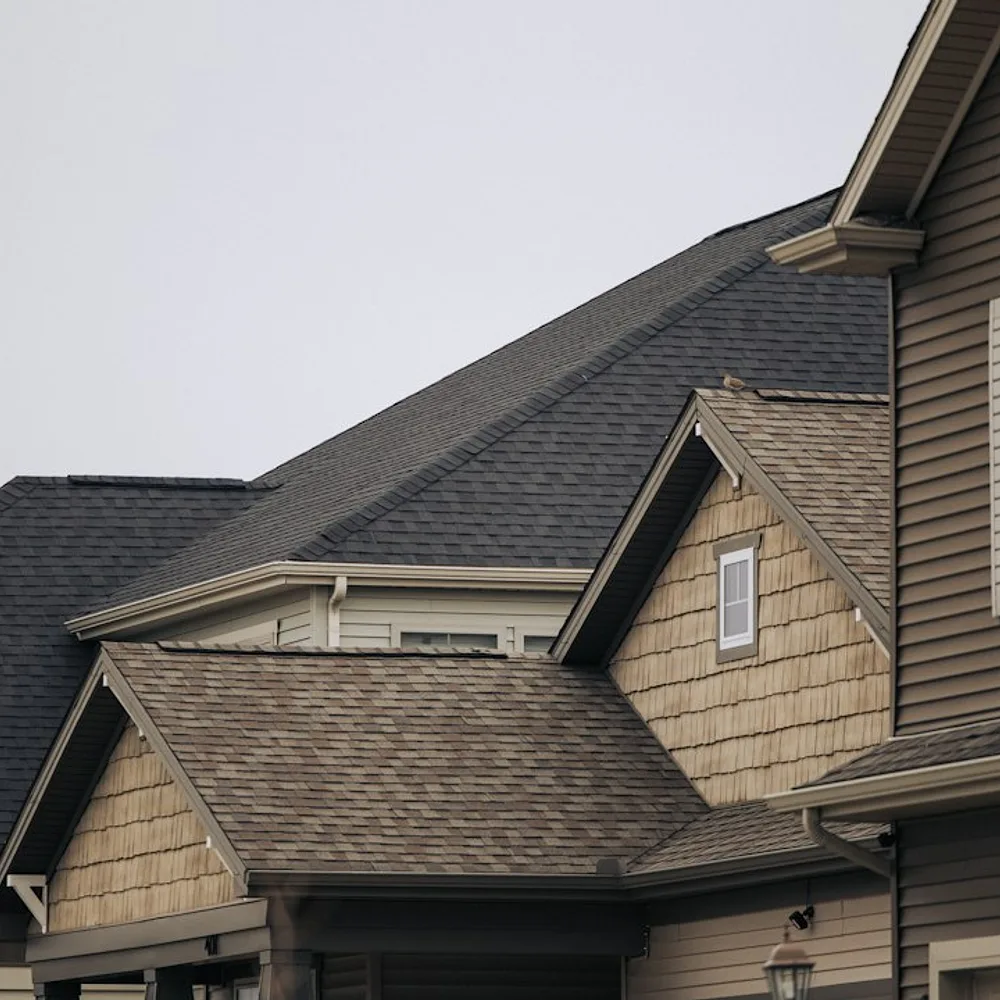 a row of houses with brown shingles and white windows