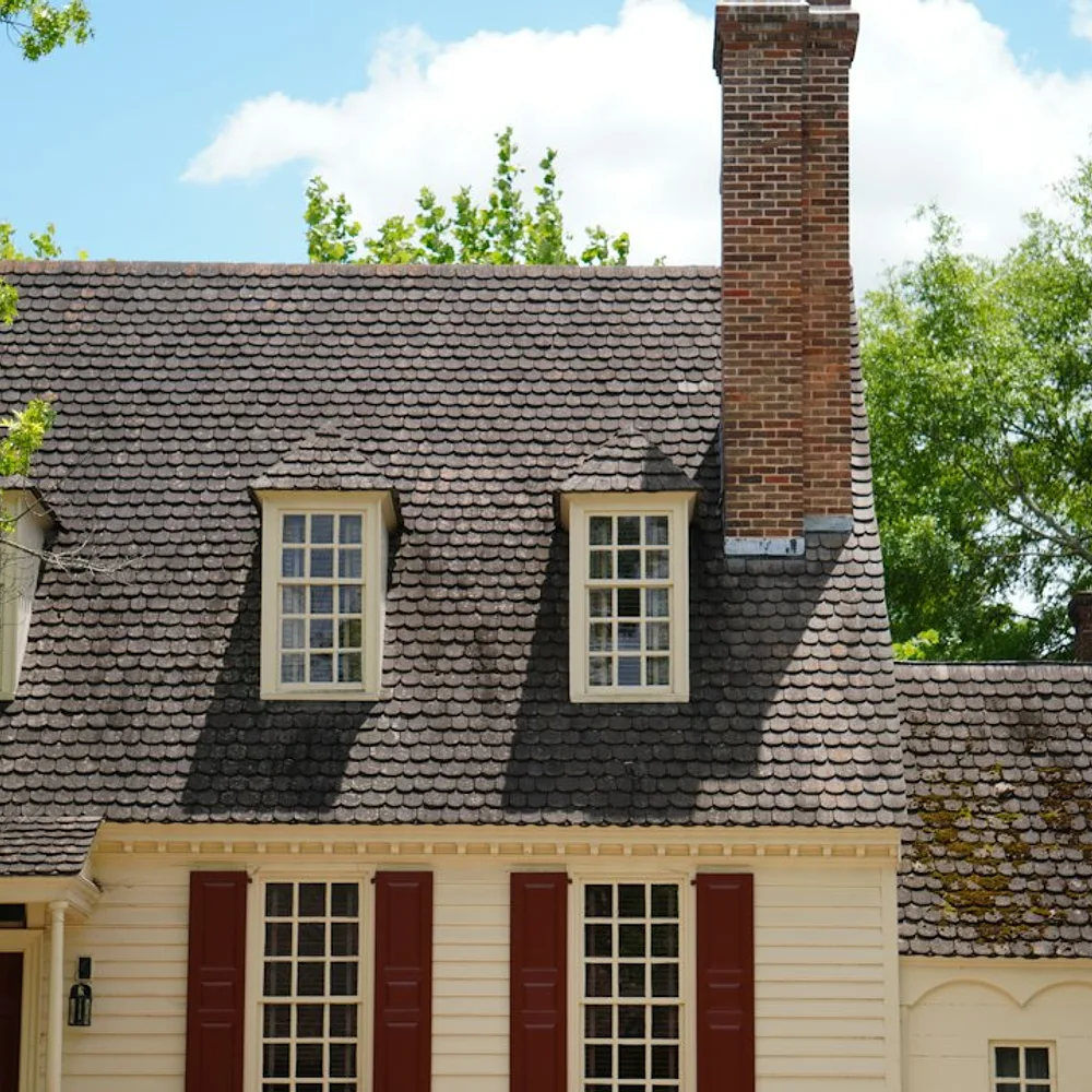 a white house with red shutters and a chimney