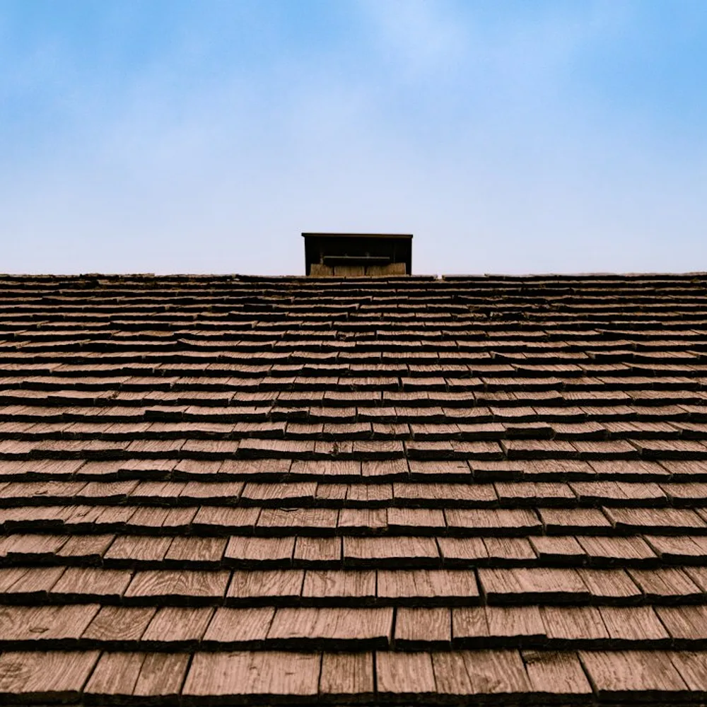 The roof of a building with a sky in the background